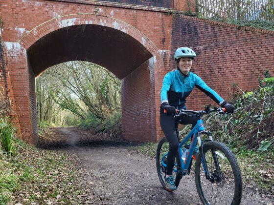 A bike is ridden along a cycle track beneath a railway bridge