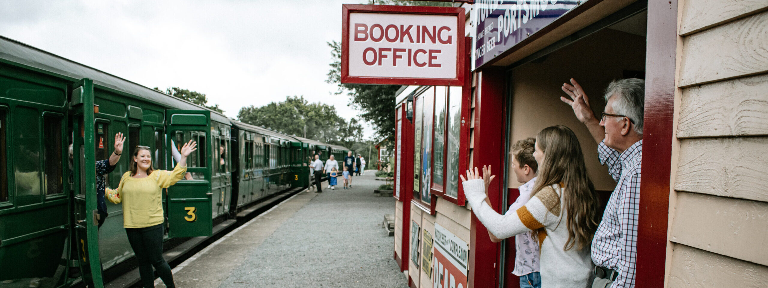 family waving at each other on the station